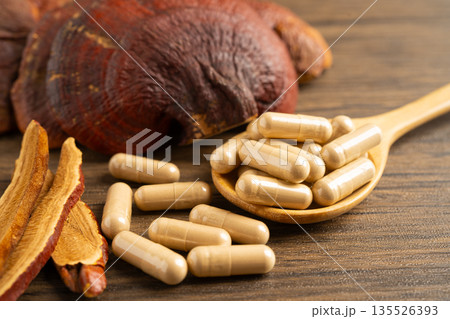 Dried lingzhi mushroom with capsule drug, alternative medicine herbal organic herb. 135526393