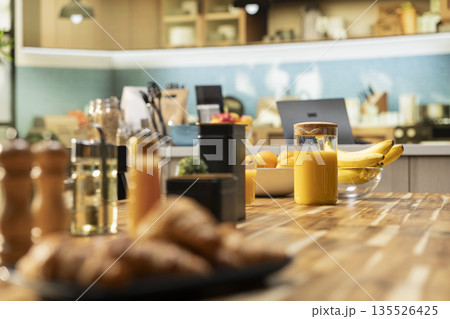 Bright modern kitchen interior with elegant furniture and wooden cupboards. Cookware and fresh vegetables on a cutting board, showcasing a stylish household and luxury home design. Bright modern kitchen interior with elegant furniture and wooden cupboards. Cookware and fresh vegetables on a cutting board, showcasing a stylish household and luxury home design. 135526425