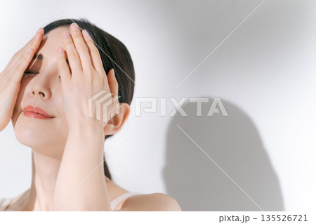 目元のスキンケアをする若い女性 135526721