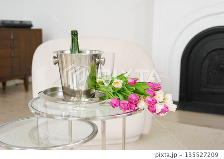 Spring white and pink tulips with champagne bottle and glasses in elegant living room, romantic mood Spring white and pink tulips with champagne bottle and glasses in elegant living room, romantic mood 135527209