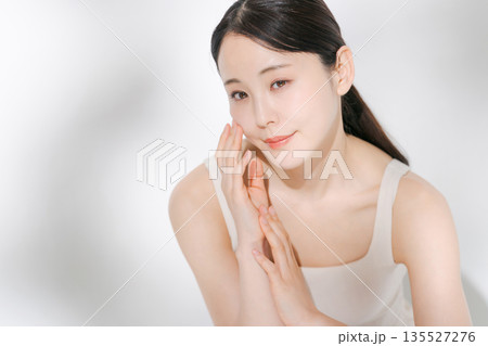 頬に手を当てる若い女性 135527276