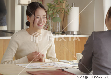 若い女性が保険や資産形成の相談をする様子 135527874