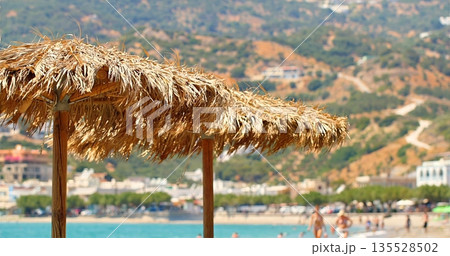Relaxing Coastal Scene With Parasol, Tranquil Beachfront Setting With Vibrant Sky And Distant Resorts Relaxing Coastal Scene With Parasol, Tranquil Beachfront Setting With Vibrant Sky And Distant Resorts 135528502