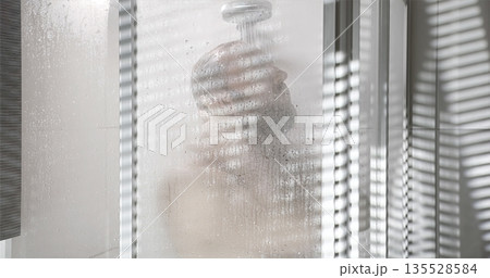 Shrouded Figure Amid Bathroom Steam, Silent Scene Of Selfcare Behind Blinds With Gentle Illumination 135528584