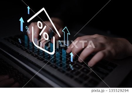 Hands typing on a laptop keyboard with digital graphs and percentage symbols representing financial analysis and growth in a dark setting Gantry 135529294