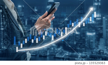 Business professional holding smartphone in front of stock market graph with increasing trend, financial growth, and city skyline at night Copula 135529363