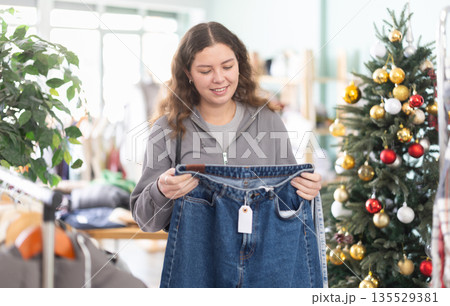 Girl at trading floor pick out jeans, X mas shopping Girl at trading floor pick out jeans, X mas shopping 135529381