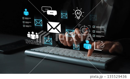 Hands typing on a keyboard with glowing icons representing digital communication, technology, and artificial intelligence interactions in a dark setting Gluon 135529436