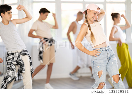 Teenage girl practicing hip hop slide moves in training hall 135529551