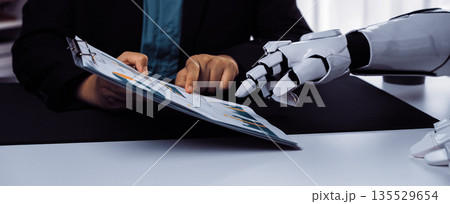 Human and Robot Collaboration in Business with Data Analysis on Clipboard at Modern Desk in Office Environment. Noogenesis Human and Robot Collaboration in Business with Data Analysis on Clipboard at Modern Desk in Office Environment. Noogenesis 135529654