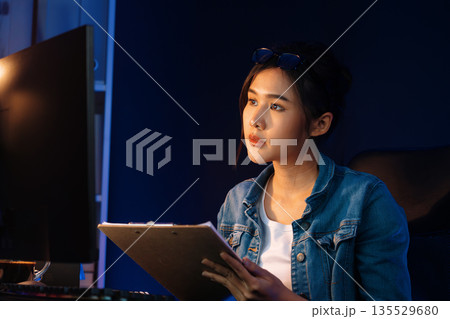 Thinking Asian woman analyzing profit comparing on email report. Stratagem. Thinking Asian woman analyzing profit comparing on email report. Stratagem. 135529680