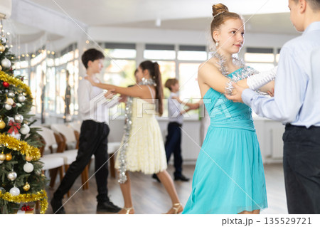 Smiling teenage girl enjoying slow dance with friend at Christmas party Smiling teenage girl enjoying slow dance with friend at Christmas party 135529721