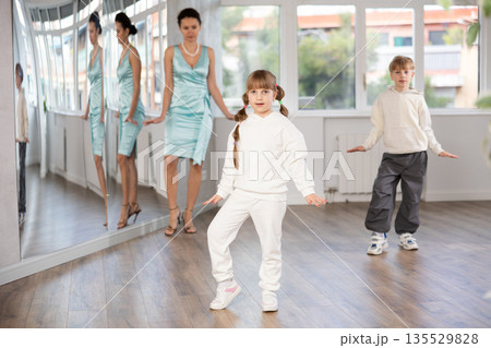 Boy and girl train to dance contemporary vigorous boogie woogie during classes. Boy and girl train to dance contemporary vigorous boogie woogie during classes. 135529828