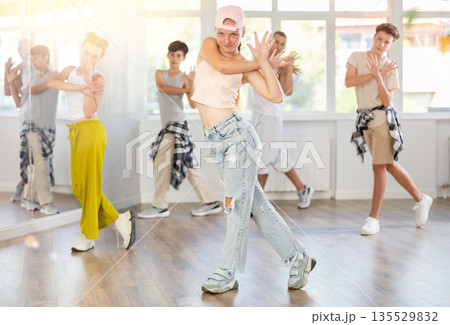 Teenage girl practicing basic hip hop moves in training hall 135529832