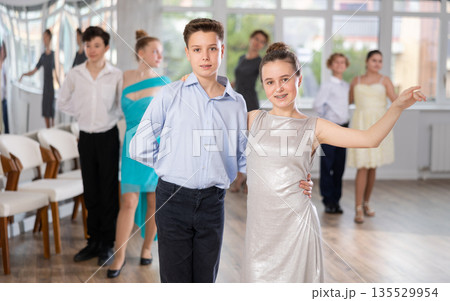 Smiling girls paired with guys dance salsa in dance class Smiling girls paired with guys dance salsa in dance class 135529954