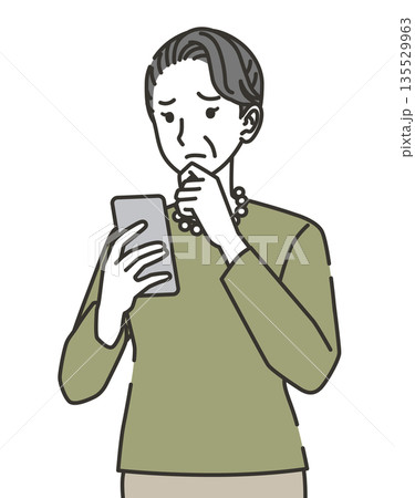スマホを見ながら悩むシニア女性 135529963