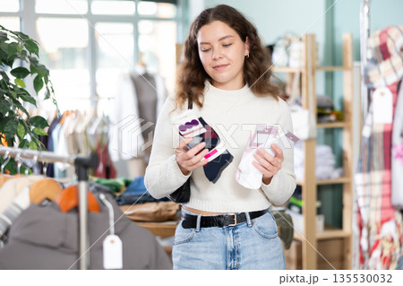 Young woman chooses socks in clothing store 135530032