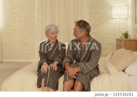 夜のベッドルームで会話するシニアの夫婦 夜のベッドルームで会話するシニアの夫婦 135530281