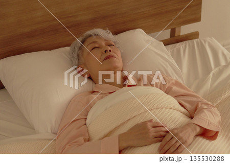 シニア女性　睡眠　ベッドルーム 135530288