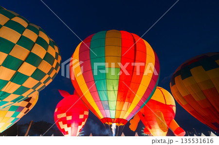 colorful hot air balloons glowing against dark night sky 135531616