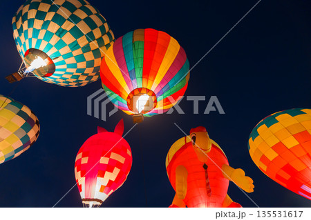 colorful hot air balloons glowing against dark night sky colorful hot air balloons glowing against dark night sky 135531617