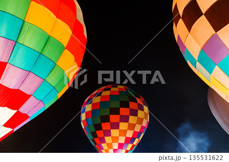 colorful hot air balloons glowing against dark night sky colorful hot air balloons glowing against dark night sky 135531622