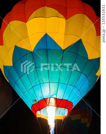 colorful hot air balloons glowing against dark night sky colorful hot air balloons glowing against dark night sky 135531631