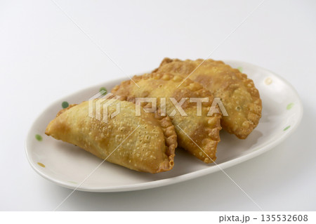 白背景にカレー揚げパイ3個が皿に盛りつけてある 135532608