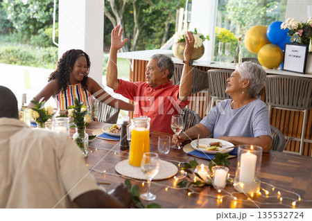 Celebrating birthday, family at outdoor table, smiling with festive meal together Celebrating birthday, family at outdoor table, smiling with festive meal together 135532724