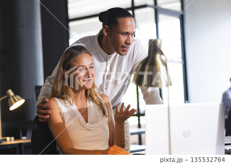 Colleagues collaborating on laptop in modern office, discussing project details Colleagues collaborating on laptop in modern office, discussing project details 135532764