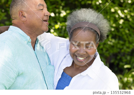 Senior couple laughing together outdoors, enjoying sunny day in garden Senior couple laughing together outdoors, enjoying sunny day in garden 135532968