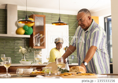 Senior couple preparing meal together in modern kitchen, enjoying quality time 135533156