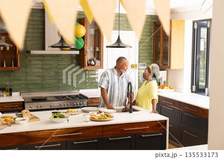 Senior couple enjoying conversation in modern kitchen with fresh meal prepared 135533173