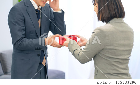 オフィスでプレゼントを渡すビジネスパーソン 135533296