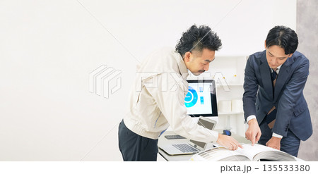 カタログを見ながら会議するビジネスパーソンと作業員のグループ 135533380