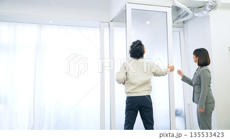 ガラスパーティションを修理する作業員 ガラスパーティションを修理する作業員 135533423