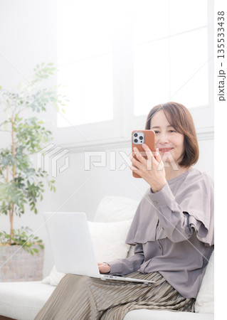 スマホで顔認証するシニア女性 135533438