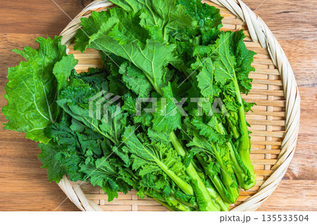 竹ざるに盛った菜の花の束 春が旬の野菜素材 135533504