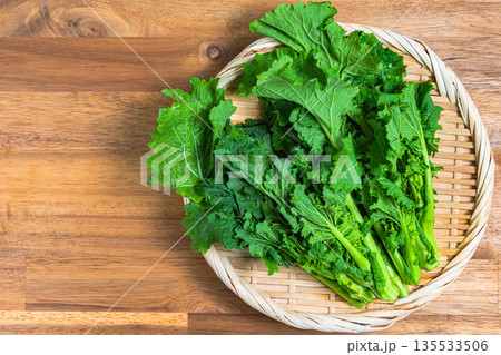 竹ざるに盛った菜の花の束 春が旬の野菜素材 135533506