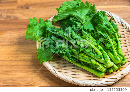 竹ざるに盛った菜の花の束 春が旬の野菜素材 135533509