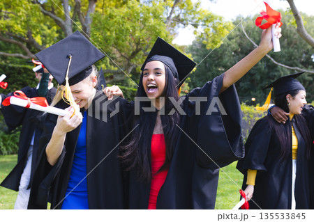 Graduating students in school celebrating with diplomas, smiling and cheering Graduating students in school celebrating with diplomas, smiling and cheering 135533845