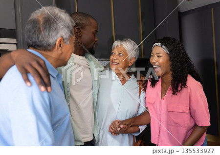 Family gathering at home, multigenerational group smiling and sharing joyful moments Family gathering at home, multigenerational group smiling and sharing joyful moments 135533927