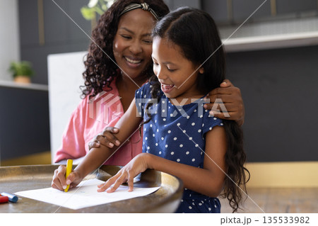 Mother and daughter drawing together at home, sharing joyful moments and creativity 135533982