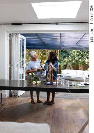Preparing food together, African American women having conversation in modern kitchen Preparing food together, African American women having conversation in modern kitchen 135534086