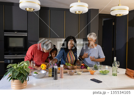 Family preparing meal together in modern kitchen, sharing joyful moments 135534105