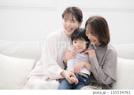 祖母と母と子どもが笑顔で抱き合う三世代家族、親子の幸せな記念写真 135534761