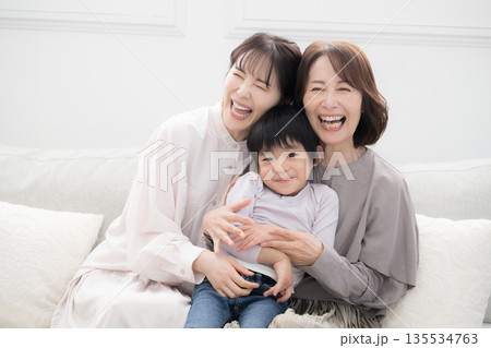 祖母と母と子どもが笑顔で抱き合う三世代家族、親子の幸せな記念写真 135534763