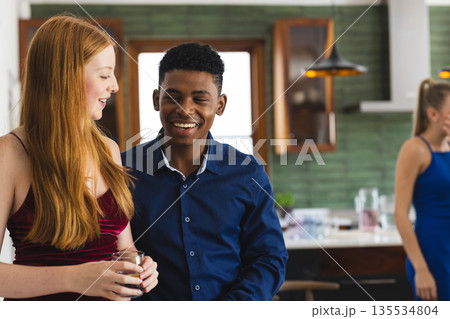 Teen friends celebrating at home, smiling and enjoying conversation together 135534804
