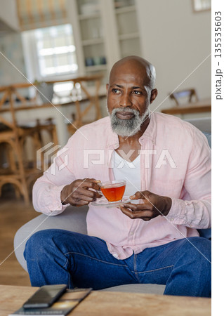 Senior man enjoying tea at home, relaxing in comfortable living room chair Senior man enjoying tea at home, relaxing in comfortable living room chair 135535603
