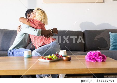 African American man and woman hugging on sofa, enjoying quality time together 135535754